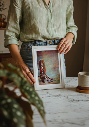 Leddy Boots Big Sky cowboy boot art print by Betsy Crum — neutral frame room mockup