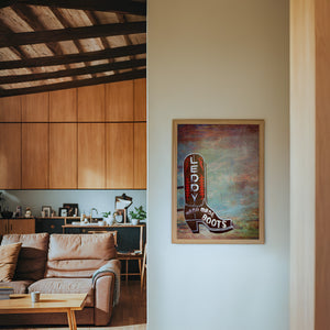 Leddy Boots Big Sky cowboy boot art print by Betsy Crum — framed in a wood-accent room
