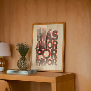 Mas Amor Por Favor typography print by Betsy Crum — framed in a wood-accent room