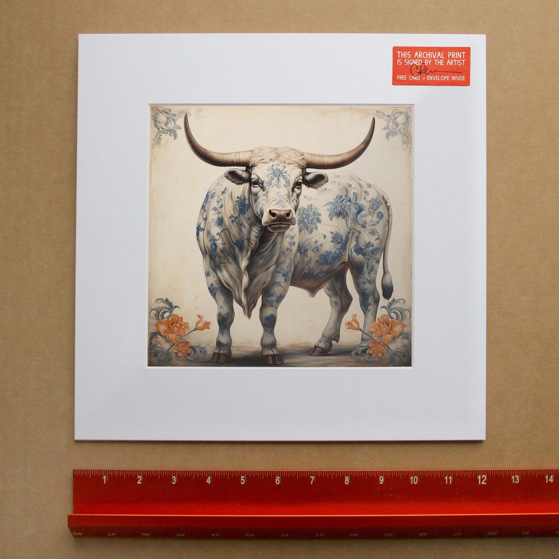 Chinoiserie Bull Print featuring a steer with blue and white floral porcelain pattern by Betsy Crum, framed and signed, with a ruler for scale