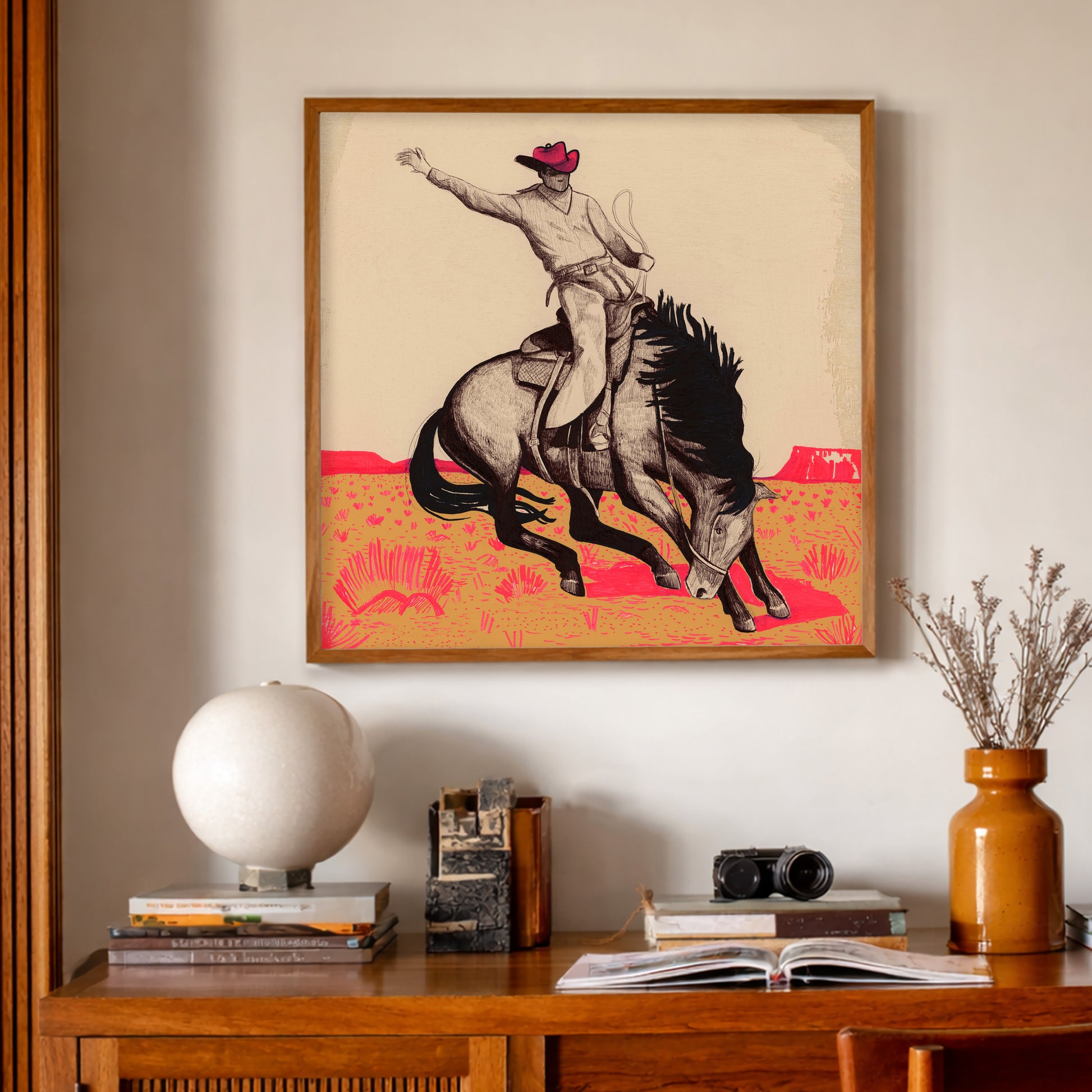 Modern Western Art Cowboy Bronc Buster Print by Caya Crum, inspired by iconic rodeo imagery, pen-and-ink detail, and a bold pink-and-beige palette that brings a sharper, more unforgettable edge to a ranch style, midcentury interior, available at crumart.com. This museum quality print is made right here in Texas.