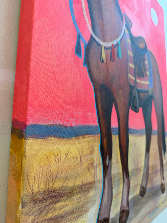 Portrait of Biscuit close-up — saddled bay pony against a pink sky, tasseled bridle detail