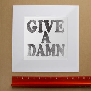 Give a Damn black on white art print by Betsy Crum shown matted in white