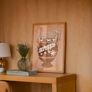 Schepps Milk Amphora kitchen art print by Betsy Crum — framed in a wood-accent room