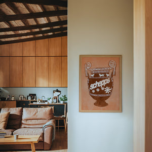 Schepps Milk Amphora kitchen art print by Betsy Crum — framed in a wood-accent room