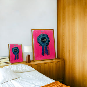Slay Ribbon funny wall art print by Caya Crum — framed in a wood-accent room