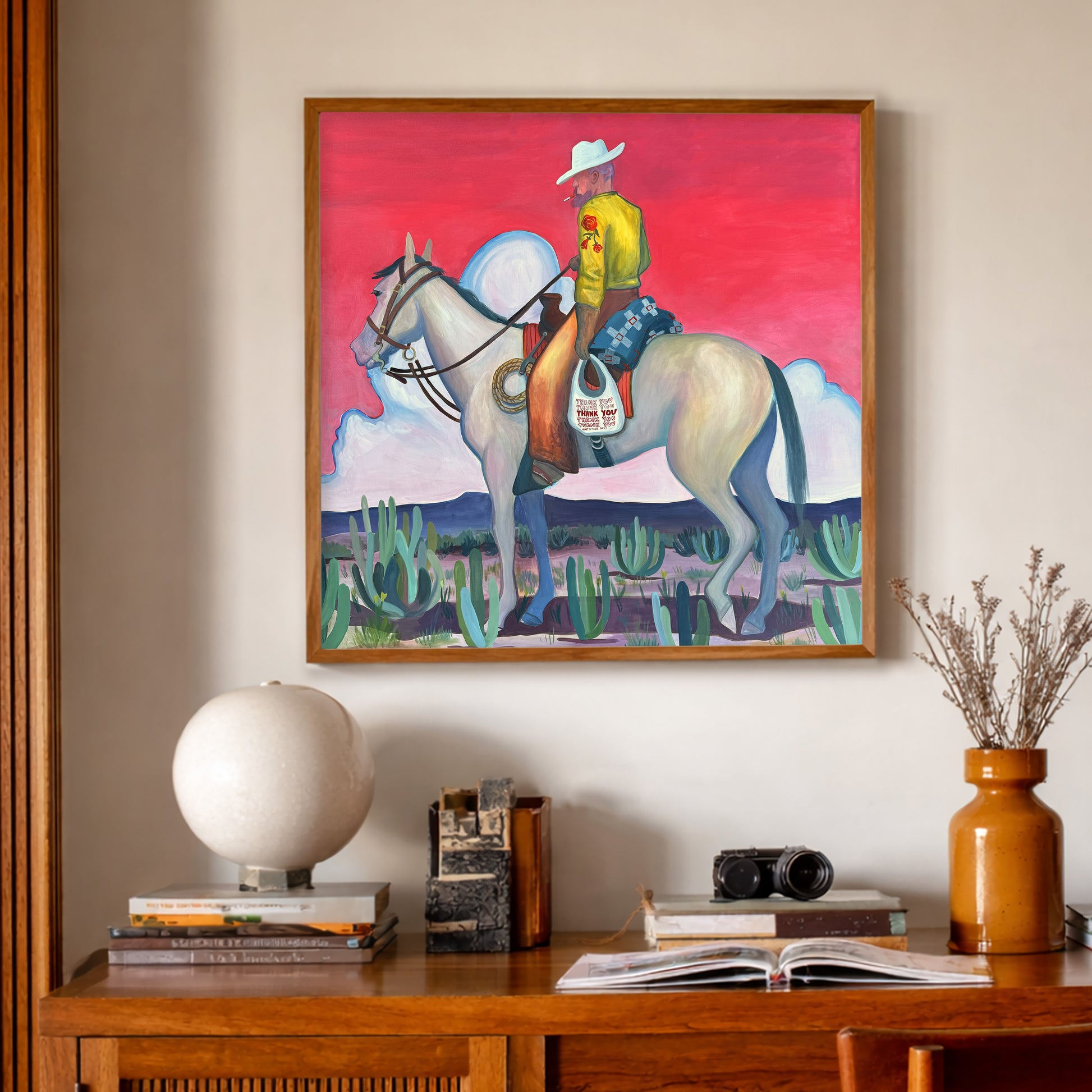 Smoking Cowboy Print features a cowboy with cigarette in his mouth and thank you bag by his side.  The pink sky give this work and other worldly feel.  Western Nostalgia combined with Cosmic Desert Energy gives a life force to this work created by Fort Worth Texas artist Caya Crum. This Texas Art Print is made in Texas.