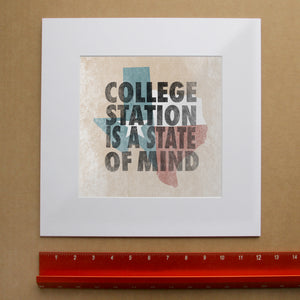 College Station State of Mind art print shown matted — bold letterpress type over a weathered Texas flag by Betsy Crum. Square Brazos Valley wall art, printed in Texas, at crumart.com.