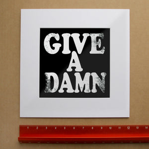 Give a Damn typography art print by Betsy Crum shown matted in white