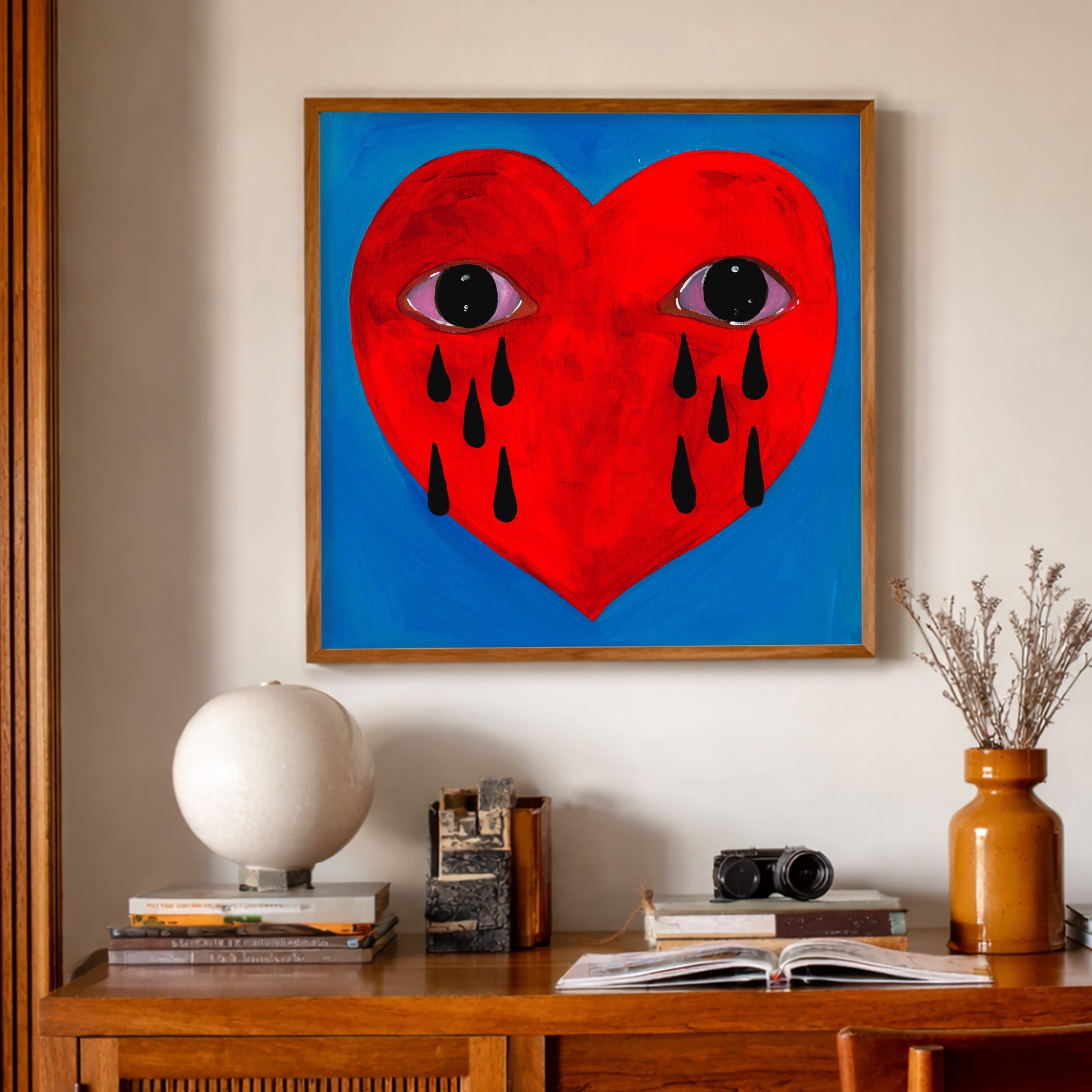 Tarot Inspired Heart Wall Art by Caya Crum, inspired by magic, witchy symbolism, devotional heart imagery, and a vivid red crying heart with eyes and black tears set against a saturated blue ground, available at crumart.com. This museum quality print is made right here in Texas.