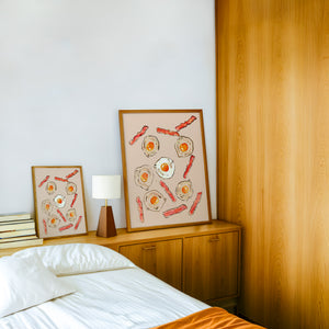 Eggs & Bacon kitchen art print by Tavi Crum — framed in a wood-accent room