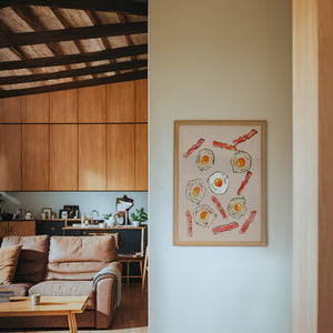 Eggs & Bacon kitchen art print by Tavi Crum — framed in a wood-accent room