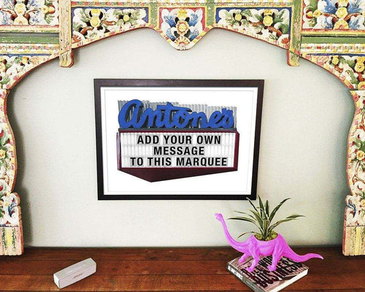 Antones Sign Austin Print by Carl Crum framed on wall with pink dinosaur planter on wooden table