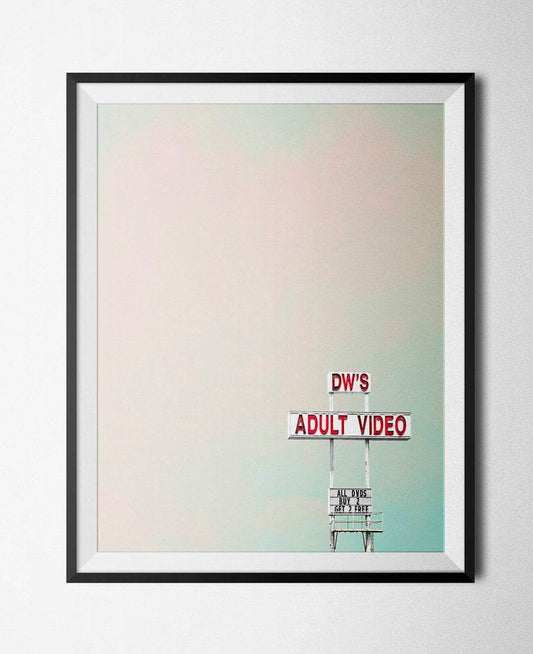 Framed art print of DW's Adult Video sign with a pastel sky background, ideal for man caves or game rooms.
