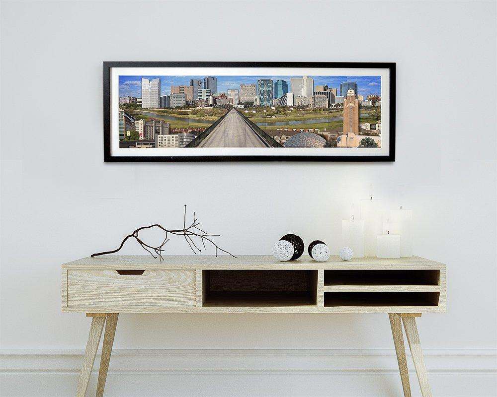 Framed Fort Worth Skyline art print by Betsy Crum above modern wooden console table with decorative items in minimalistic room