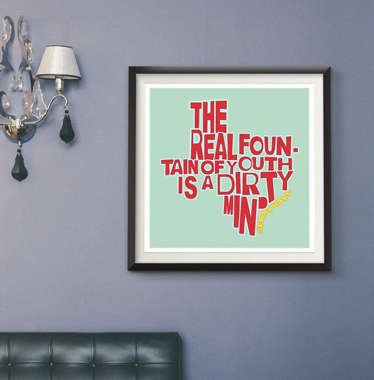 Jerry Hall Quote framed print with red and yellow text "The Real Fountain of Youth is a Dirty Mind" on light blue background