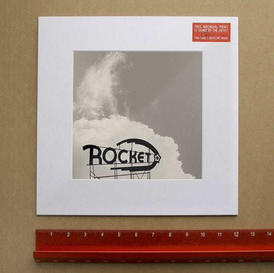 Black and white archival museum print of the Rocket Fort Worth sign mounted on white mat with ruler for scale