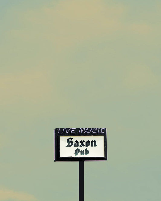 Museum print of Saxon Pub sign with live music text on a greenish sky background