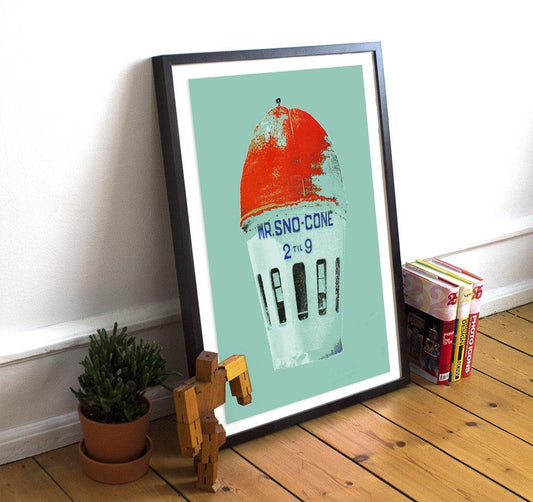 Framed Fort Worth Sno Cone museum print on acid-free cotton paper leaning against wall on wooden floor next to plant and wooden figure