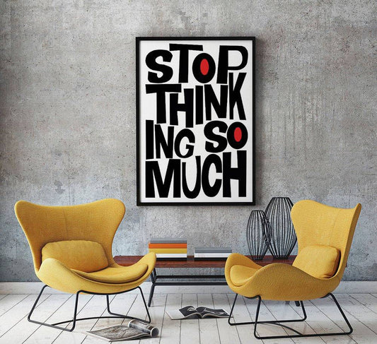 Stop thinking so much motivational quote print in black and red typography framed on wall above modern yellow chairs in living room