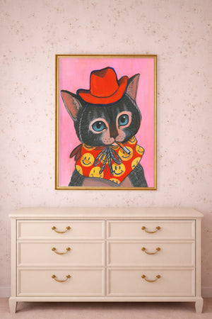 Grey Tabby Cat Art Print.  This Cat is a cowboy and he is smoking a cigarette.  the dominant colors are pink and red. This Western themed Painting by Caya Crum is a signed  art print of an original acrylic painting by Caya Crum.  He is wearing a red cowboy hat, smoking a Marlboro red cigarette, the cat has big blue eyes, the cat is personified with a smiley face kerchief around his neck.  This print is shown here in a gold frame in a bedroom.   All art printed to order at our studio in Fort Worth Texas. 