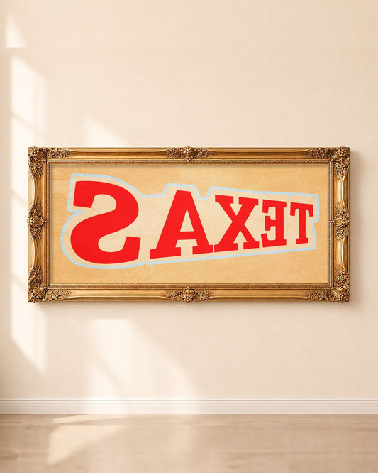 Cool Texas backwards TEXAS panoramic art print by Betsy Crum in a long gold frame on a sunlit wall
