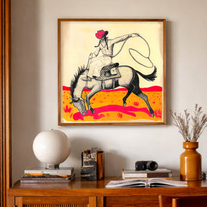 Cowgirl roping art print with pink cowboy hat styled above a wooden console