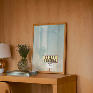 Dollar General Marfa art print by Betsy Crum — framed in a wood-accent room