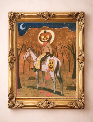 Jack-O-Lantern Cowboy Halloween art print by Caya Crum in a gold frame — a pumpkin-headed cowboy on a gray horse in an autumn wood under a crescent moon