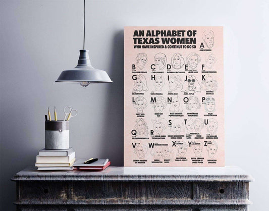 Alphabet Of Texas Women art print by Caya Crum displayed on desk with modern lamp and office supplies