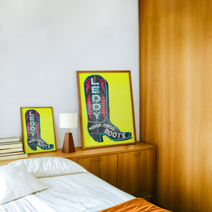 Leddy Boot Yellow cowboy boot art print by Betsy Crum — framed in a wood-accent room