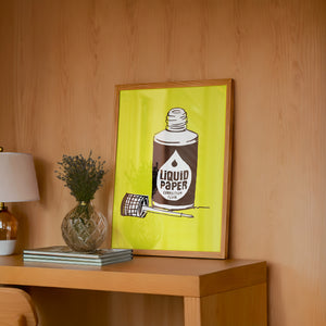 Liquid Paper office wall art print by Betsy Crum — framed in a wood-accent room
