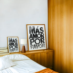 Mas Amor Por Favor typography print by Betsy Crum — framed in a wood-accent room