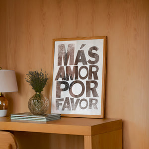 Mas Amor Por Favor typography print by Betsy Crum — framed in a wood-accent room