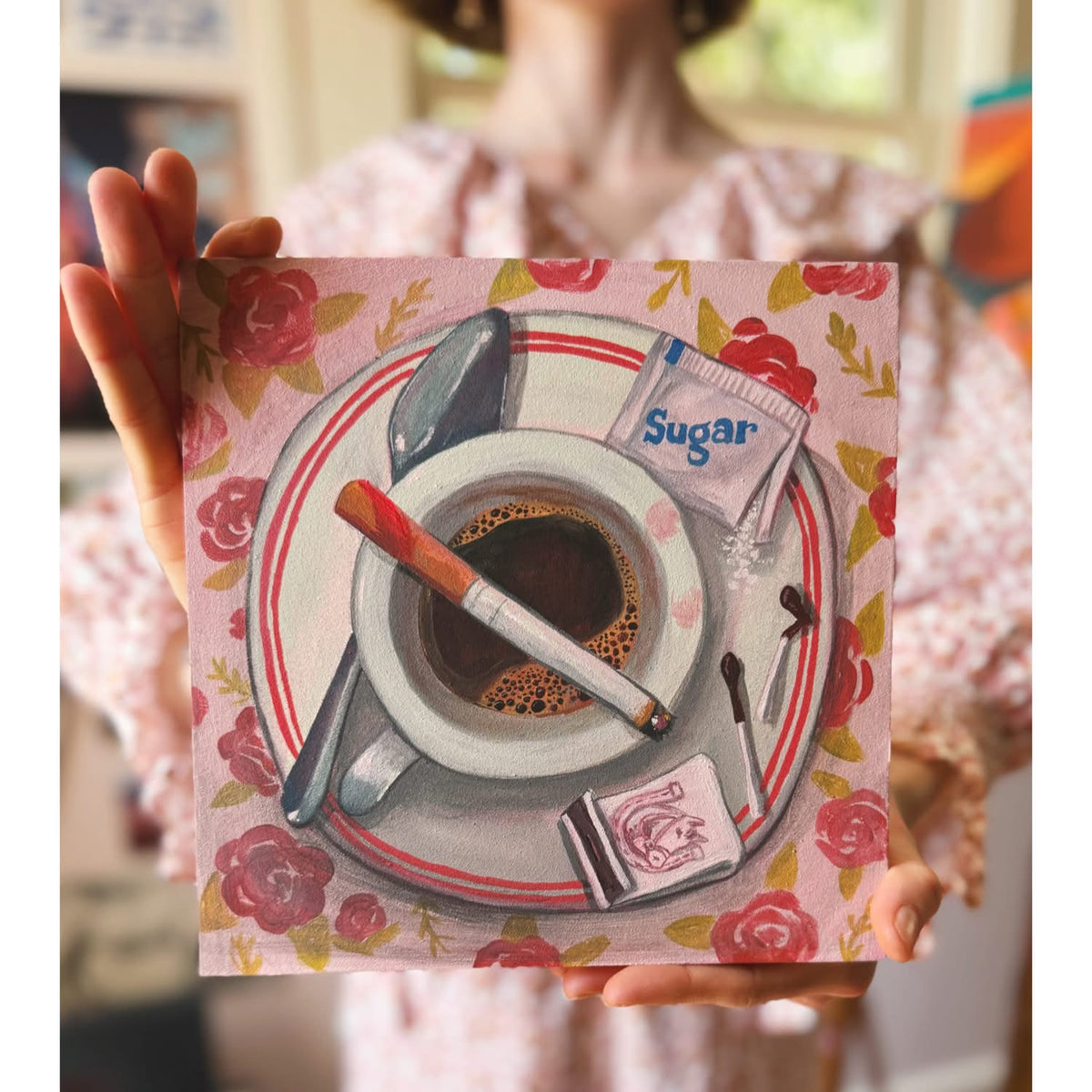 Artist Caya Crum with the original painting European Breakfast — a breakfast plate on a patterned cloth, 10 x 10 inches