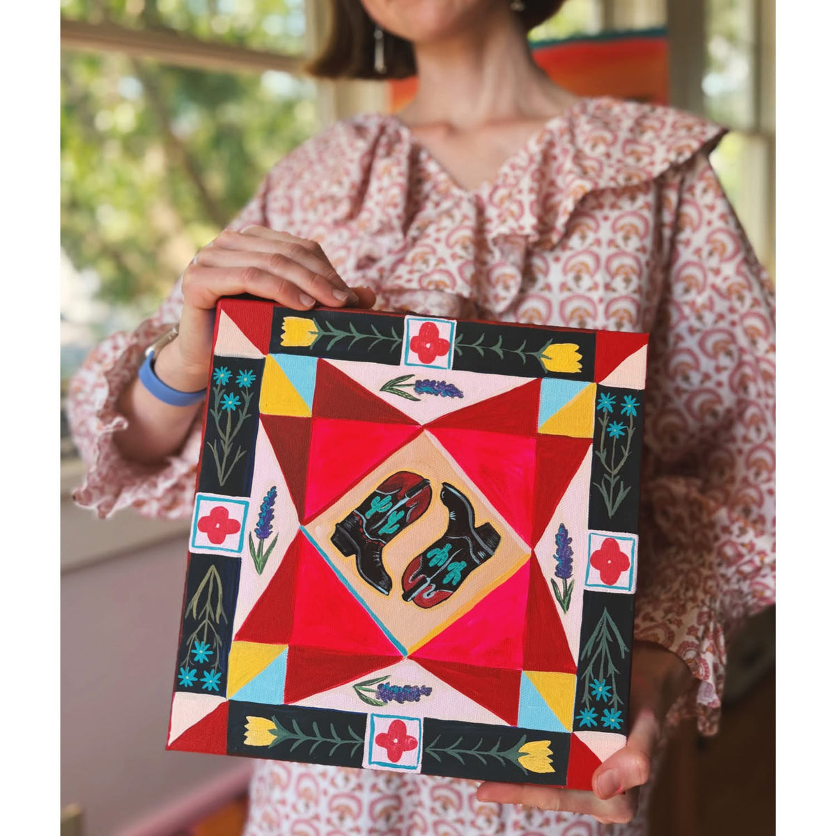 Artist Caya Crum with the original painting Patchwork Boots — cowboy boots on a patchwork quilt ground, 12 x 12 inches