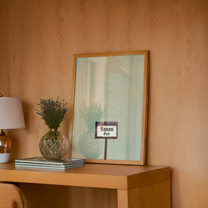 Saxon Pub Austin print by Betsy Crum — framed in a wood-accent room