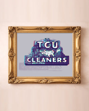 TCU Cleaners sign art print by Betsy Crum in a horizontal gold frame, the purple Fort Worth sign with its leaping horned frog